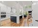 Open kitchen showcasing white cabinets, stainless steel appliances, and hardwood floors at 1589 Bennett Creek Overlook, Suwanee, GA 30024
