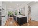 Modern kitchen features stainless appliances, white cabinets, an island, and hardwood floors at 1589 Bennett Creek Overlook, Suwanee, GA 30024