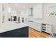 Bright kitchen with white cabinets, stainless appliances, an island with seating and hardwood floors at 1589 Bennett Creek Overlook, Suwanee, GA 30024