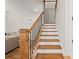 Bright foyer staircase with hardwood steps, black iron spindles, and stained wood handrail at 1589 Bennett Creek Overlook, Suwanee, GA 30024