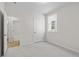 Bright bedroom with light gray carpet, white walls, trim and doors and a view into the entryway and bathroom at 1682 Juniper Berry Way, Loganville, GA 30052