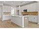 Spacious kitchen offers white cabinets, island with seating, and modern light fixtures at 1682 Juniper Berry Way, Loganville, GA 30052