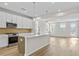 Modern kitchen boasts an island, stainless appliances, and open layout to living area at 1682 Juniper Berry Way, Loganville, GA 30052