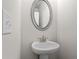 Charming powder room with pedestal sink, oval mirror, and neutral wall color at 1682 Juniper Berry Way, Loganville, GA 30052