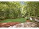 Large grassy backyard surrounded by lush trees and mature landscaping at 2672 Birchwood Dr, Atlanta, GA 30305