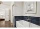 Bathroom with a white bathtub, blue tile accent, and artwork at 2672 Birchwood Dr, Atlanta, GA 30305