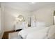 Bright bedroom showcasing a white dresser, round mirror, and light-colored bedding at 2672 Birchwood Dr, Atlanta, GA 30305