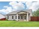 Backyard featuring a covered porch, lush green grass, and wooden fence at 306 Lark Ln, Canton, GA 30115