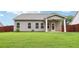 Backyard with lush green grass and partial view of the house with covered porch at 306 Lark Ln, Canton, GA 30115