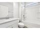 Bright bathroom featuring a shower-tub combo, white cabinetry, and a granite countertop vanity at 306 Lark Ln, Canton, GA 30115