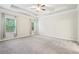 Spacious bedroom featuring tray ceiling, a ceiling fan, carpet, and multiple windows providing plenty of natural light at 306 Lark Ln, Canton, GA 30115