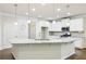 Bright kitchen with white cabinetry, granite countertops, and a large island with pendant lighting at 306 Lark Ln, Canton, GA 30115