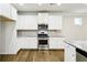 Modern kitchen featuring stainless steel appliances, white cabinets, and granite countertops at 306 Lark Ln, Canton, GA 30115