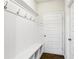 Bright mudroom with coat hooks, white wainscoting, bench seating, and storage shelves, providing organization and style at 306 Lark Ln, Canton, GA 30115
