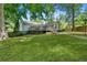 Spacious backyard featuring mature trees, manicured lawn, patio, and beautiful landscaping at 3116 Lakepoint Cir, Acworth, GA 30102