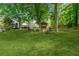 Spacious backyard with manicured lawn, firepit, seating area, gazebo, and mature trees at 3116 Lakepoint Cir, Acworth, GA 30102