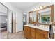 Bright bathroom with double sinks, wood cabinets, a view to the outside, and ample storage space at 3116 Lakepoint Cir, Acworth, GA 30102