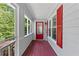 Inviting front porch with a red door, decorative shutters, and a cozy ambiance at 3116 Lakepoint Cir, Acworth, GA 30102