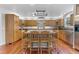 Open kitchen with hardwood floors, wood cabinets, stainless appliances, and eat-in island at 3116 Lakepoint Cir, Acworth, GA 30102