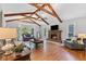 Bright living room featuring a brick fireplace, hardwood floors, and beamed ceilings at 3116 Lakepoint Cir, Acworth, GA 30102