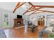 Cozy living room featuring a brick fireplace, hardwood floors, and beamed ceilings at 3116 Lakepoint Cir, Acworth, GA 30102