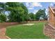 Large backyard with a fire pit and a well-maintained lawn, enclosed by a wood picket fence at 11040 Regal Forest Dr, Johns Creek, GA 30024