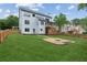 Backyard of a two-story home featuring a fire pit area and a wooden deck and screened in porch at 11040 Regal Forest Dr, Johns Creek, GA 30024