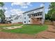 Spacious backyard with a fire pit, wood fence, and a view of the home's deck and screened porch at 11040 Regal Forest Dr, Johns Creek, GA 30024