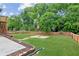 Spacious backyard with mature trees, a fire pit, and a wood fence at 11040 Regal Forest Dr, Johns Creek, GA 30024