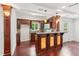 The wet bar features wooden cabinets, pendant lights, granite counters, tile backsplash, and hardwood floors at 11040 Regal Forest Dr, Johns Creek, GA 30024