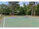 Community basketball court with trees and a bench, perfect for outdoor activities at 11040 Regal Forest Dr, Johns Creek, GA 30024