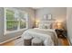 Comfortable bedroom with soft natural light from two large windows and calm neutral decor at 11040 Regal Forest Dr, Johns Creek, GA 30024