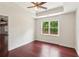 Bedroom with wood floors, tray ceiling, neutral walls, ceiling fan, and large window overlooking the backyard at 11040 Regal Forest Dr, Johns Creek, GA 30024