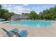 Community pool with lounge chairs, umbrellas, and the pool house, surrounded by lush greenery at 11040 Regal Forest Dr, Johns Creek, GA 30024