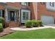 Close-up view of a home's front entrance, highlighting the door, front yard, and two-car garage at 11040 Regal Forest Dr, Johns Creek, GA 30024