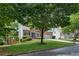 Attractive brick home with a well-manicured lawn, lush trees, and a two-car garage at 11040 Regal Forest Dr, Johns Creek, GA 30024