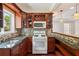 Bright kitchen featuring granite counters, tile backsplash, wood cabinets, and stainless steel appliances at 11040 Regal Forest Dr, Johns Creek, GA 30024