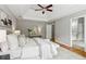 Spacious main bedroom with a tray ceiling, ceiling fan, and access to an ensuite bathroom at 11040 Regal Forest Dr, Johns Creek, GA 30024