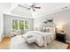 Elegant main bedroom with tray ceiling, ceiling fan and ample natural light at 11040 Regal Forest Dr, Johns Creek, GA 30024