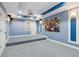 Finished media room with blue walls, projector, carpet floors, sconces, and built in shelving at 11040 Regal Forest Dr, Johns Creek, GA 30024