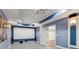 Finished media room with projector, screen, blue walls, carpet floors, and wall sconces at 11040 Regal Forest Dr, Johns Creek, GA 30024