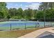 Outdoor tennis court with benches and trees, as well as a view of the Riverwalk at 11040 Regal Forest Dr, Johns Creek, GA 30024