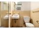 A compact full bathroom with yellow tile, a toilet, and a pedestal sink at 1491 Boulderwoods Dr, Atlanta, GA 30316