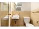 This bathroom features a standard toilet, a sink, and yellow tile at 1491 Boulderwoods Dr, Atlanta, GA 30316