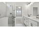 Bathroom featuring glass shower, double sinks and quartz countertop at 1783 Juniper Berry Way, Loganville, GA 30052