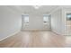 Spacious bedroom featuring tray ceilings, large windows offering lots of natural light, and hardwood flooring at 1783 Juniper Berry Way, Loganville, GA 30052