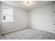 Bright bedroom with neutral carpet, a ceiling light, and a large window at 1783 Juniper Berry Way, Loganville, GA 30052