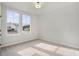 A bright bedroom featuring neutral walls, carpet flooring, with two windows providing natural light and neighborhood views at 1783 Juniper Berry Way, Loganville, GA 30052