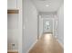 Bright hallway with neutral walls, hardwood flooring, and a view of the front door and other rooms at 1783 Juniper Berry Way, Loganville, GA 30052
