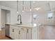 Kitchen island boasts white cabinets, a sink and stainless steel dishwasher at 1783 Juniper Berry Way, Loganville, GA 30052